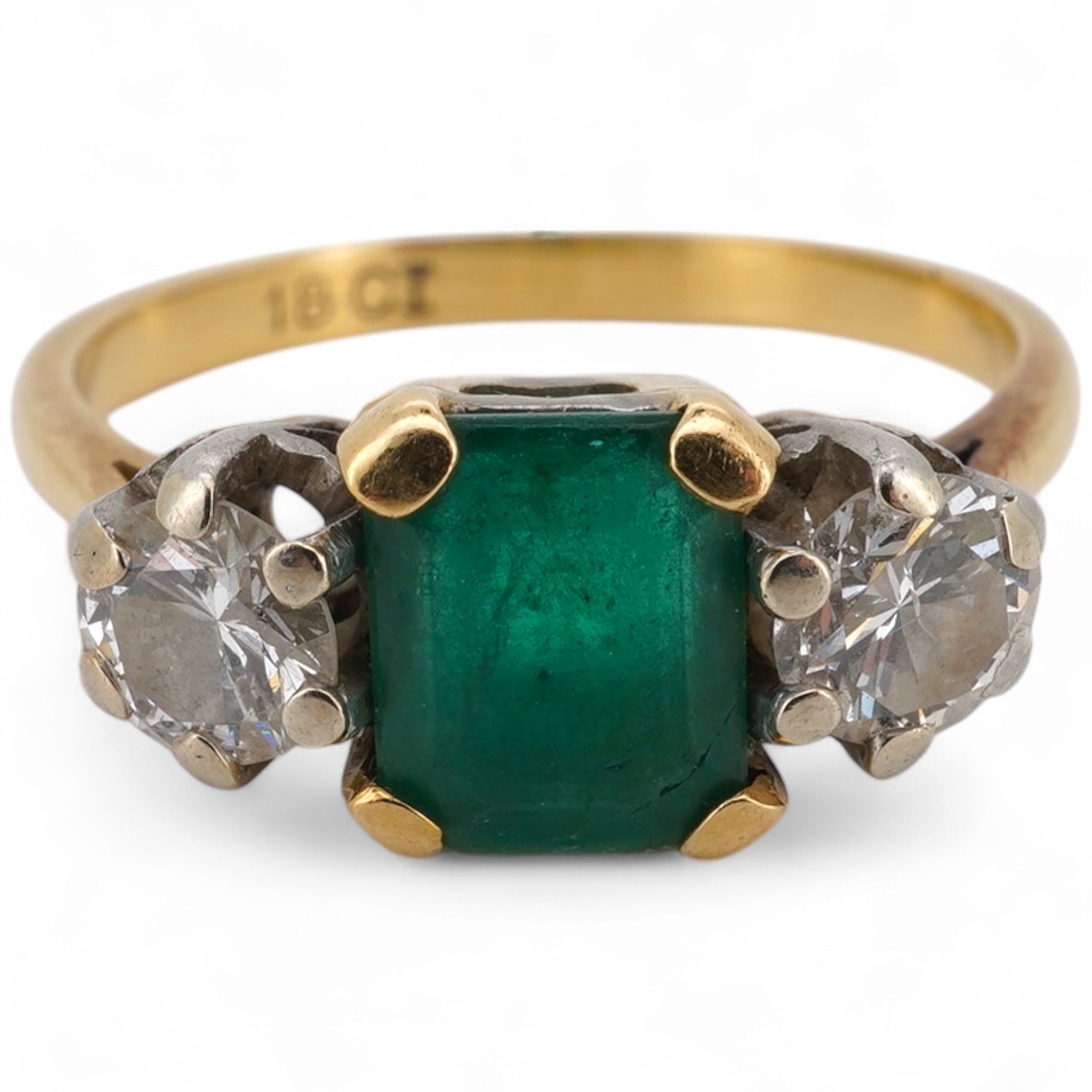 An 18ct, emerald and diamond set three stone ring, size M, gross weight 3.7 grams, (emerald cracked).